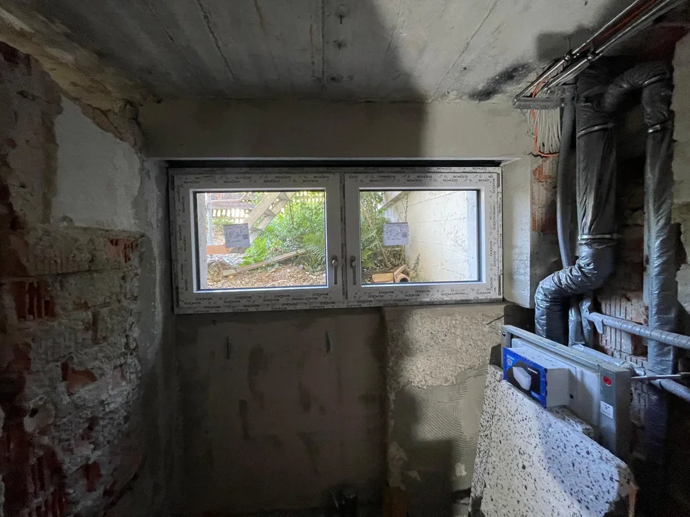 Neu montiertes Kellerfenster (Schüco, 2-flügelig), Innenansicht im Rohbau