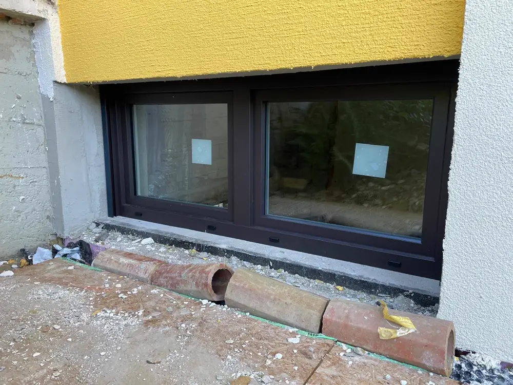 Neu montiertes Kunststoffalufenster in Anthrazit an Kellergeschoss