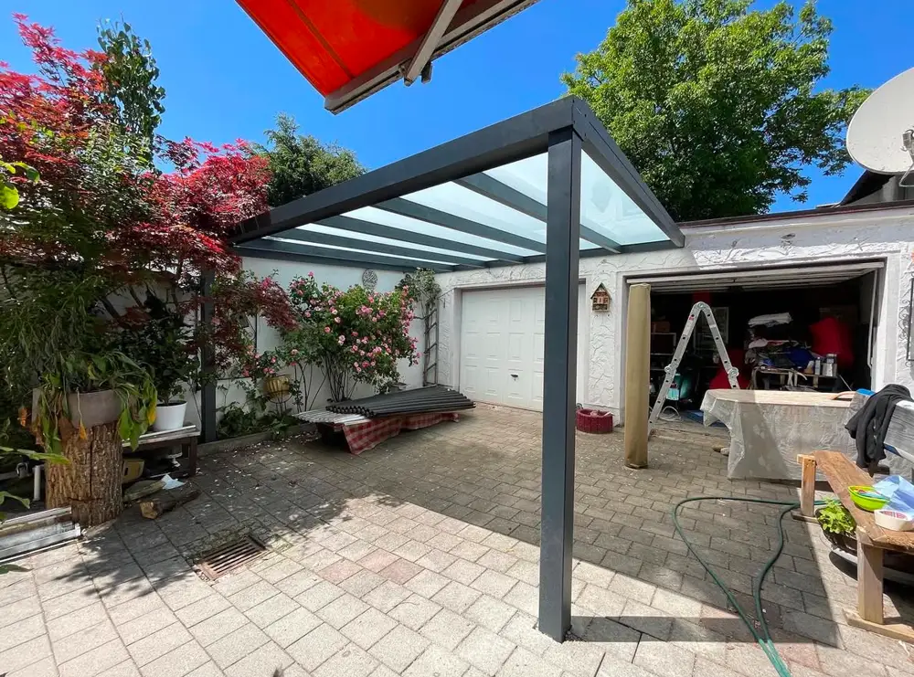 Terrassendach aus Glas über Garageneinfahrt montiert
